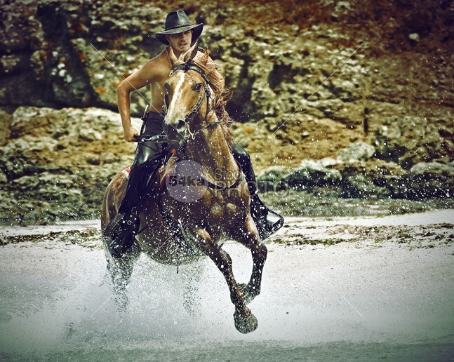 cowboy riding horse in the water and splash water drops wet