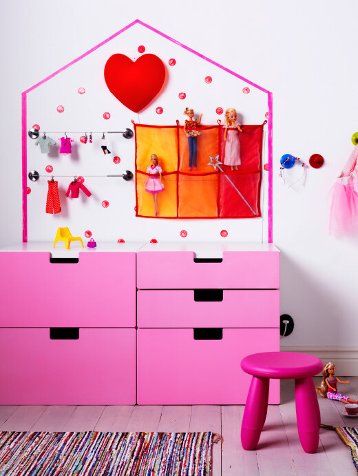 靠墙摆放的粉色抽屉柜,上面画着房子形状的图案