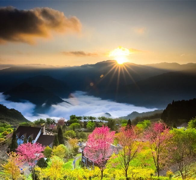 台湾东升镇日出,太阳穿过厚厚的云层升起,光芒照耀着风景秀美的小镇