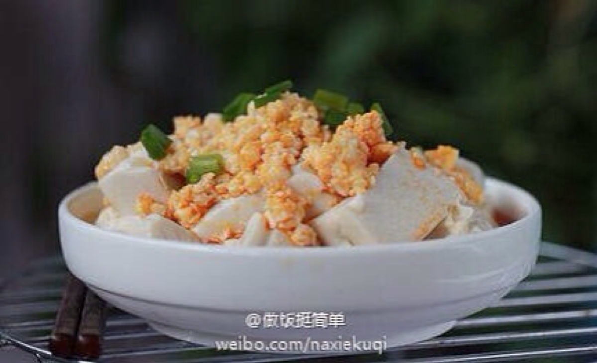 把咸鸭蛋倒入豆腐里;4.加入两勺左右的辣油;5.加入一勺麻油;6.