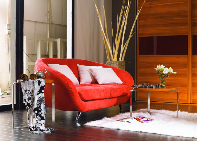 贝尔地板小编温馨提示:深色地板搭配红色小型沙发,在家居装修中既节省