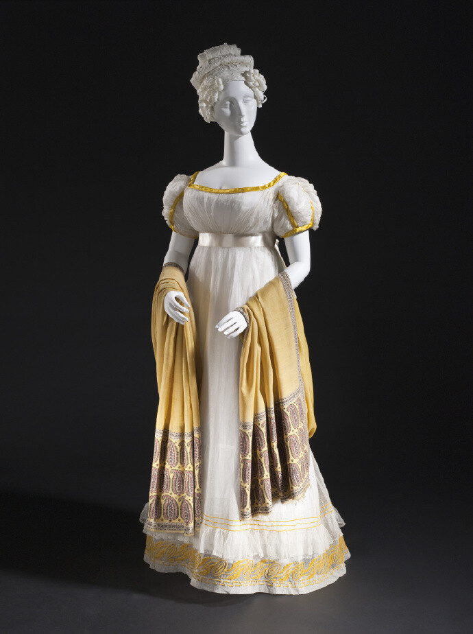 1820年的一件法国女装,帝政款,轻薄的白色棉纱,亮金色缎带镶边,裙摆上