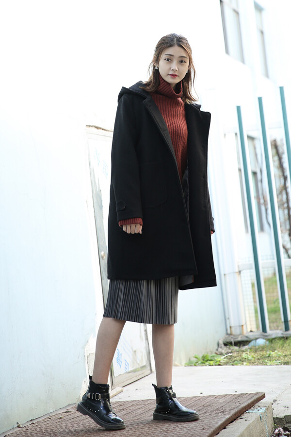 黑色连帽大衣显瘦又经典,搭配砖红色毛衣和…