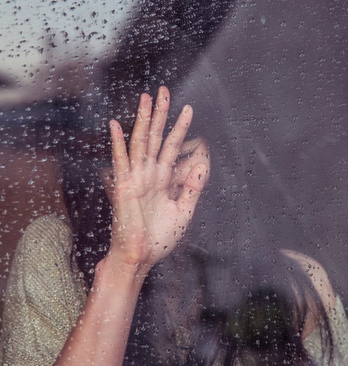 有雨的玻璃窗里的人